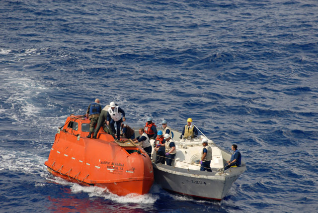 US Navy sailors from the amphibious assault ship USS Boxer connects a tow line to the lifeboat from the Maersk Alabama to be processed for evidence after the successful rescue of Capt. Richard Phillips April 13, 2009 in the Indian Ocean. Phillips was held