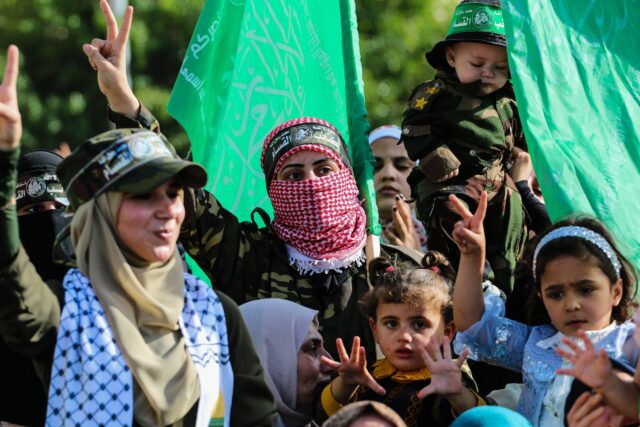 Gaza, Palestine. 30th May, 2021. Women with kids making victory gestures, during the rally.Palestinian Hamas staged an anti-Israel rally in the northern Gaza Strip, a parade with weapons in the streets of Gaza city more than a week after a ceasefire betwe
