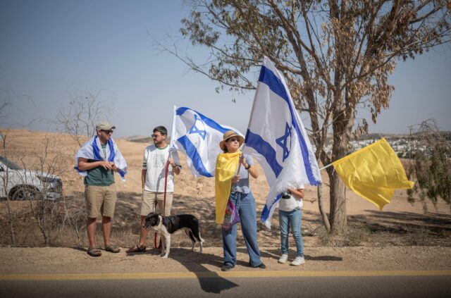 Bnei Shimon, Israel. 17th Oct, 2025. People holding Israeli flags wait to welcome freed hostage Omri Miran to Kibbutz Kramim after he was released from the hospital. Credit: ILIA YEFIMOVICH/dpa/Alamy Live News