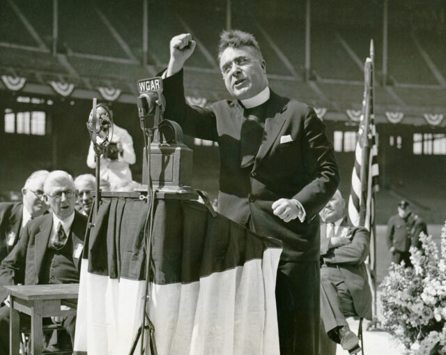 Father Coughlin (1891-1979),Father Coughlin addresses large Cleveland rally with right fist raised, speaking at rally, prior to Father Coughlin addresses a rally at a stadium in Cleveland, Ohio, in 1936.
